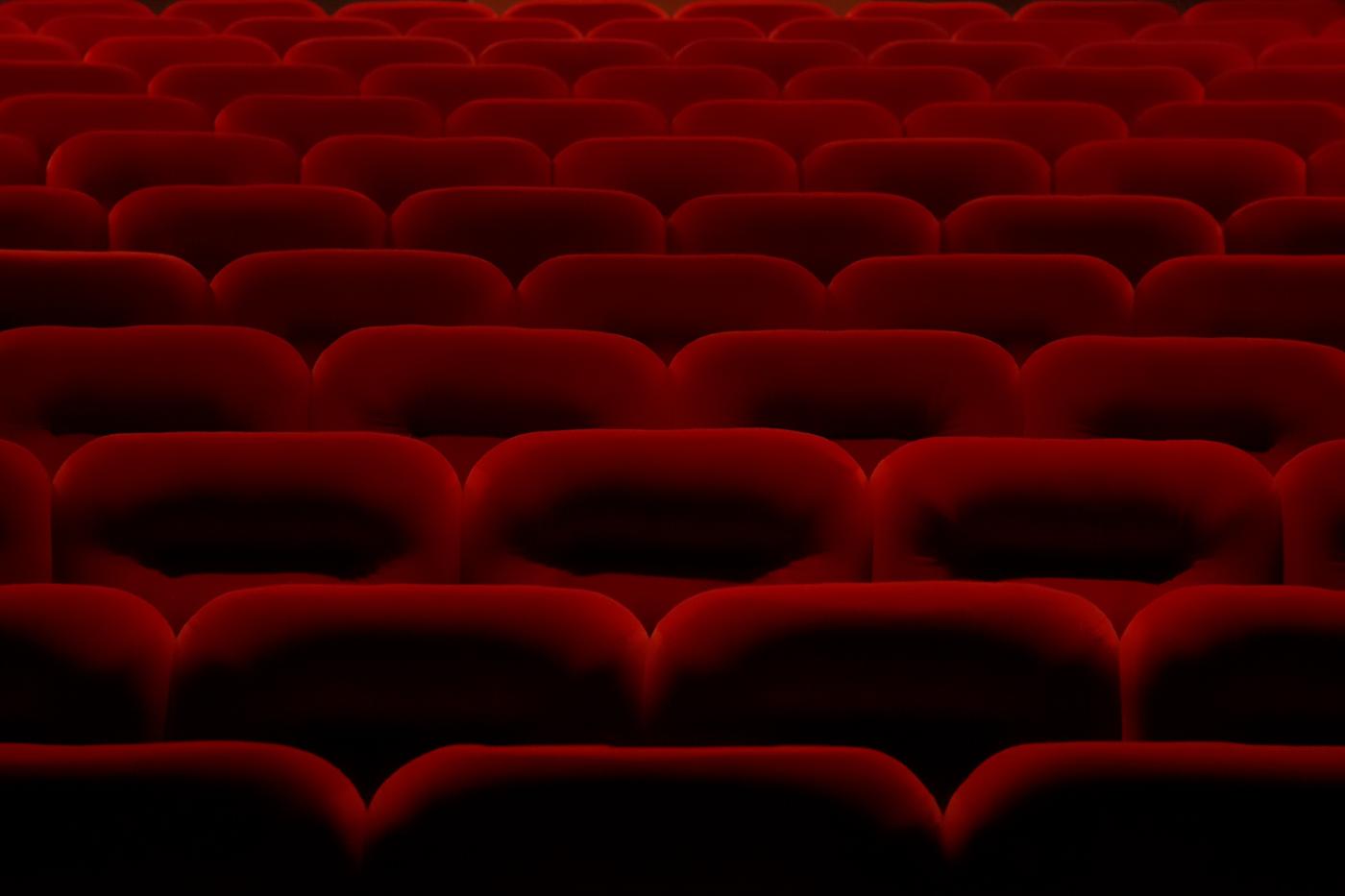 Fileiras de poltronas vermelhas de cinema vazias